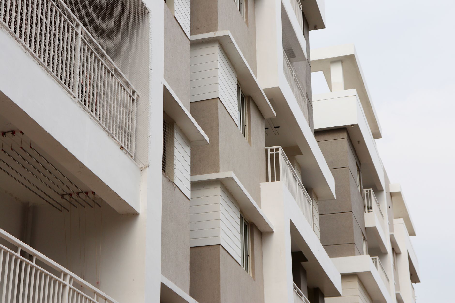Apartment building beside open plots, representative of the plots vs flats choice